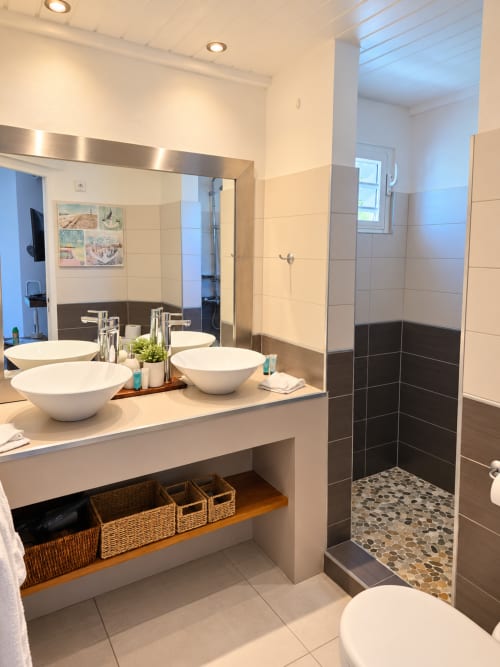 Modern bathroom with dual sinks, walk-in shower, and sea view at Les Balcons D'oyster Pond, Saint-Martin