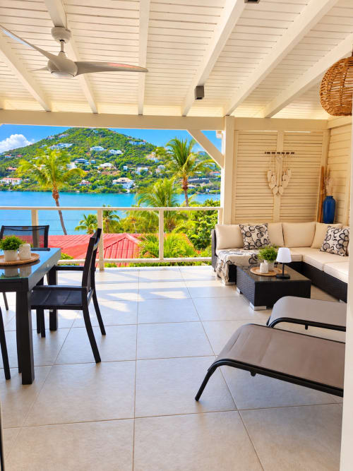 Beachfront bungalow terrace in Saint-Martin with sea views, lounge seating, and tropical hillside landscape