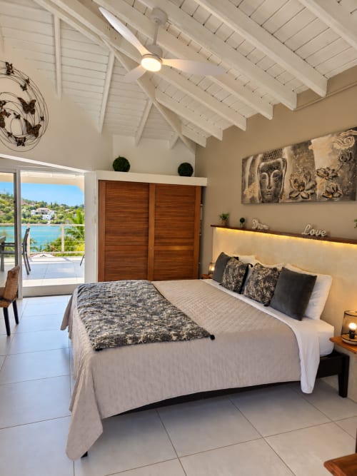Luxury bedroom at Les Balcons D'oyster Pond, Saint-Martin, with sea view, white beamed ceiling, king bed, and terrace access