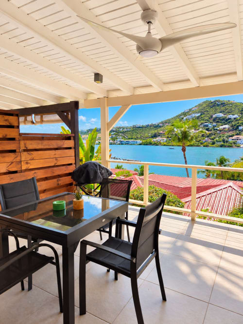 Terrasse vue océan aux Balcons d'Oyster Pond, Saint-Martin avec table à diner, pergola ombragée et vue sur la baie turquoise