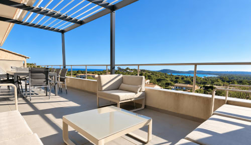 Terrasse de l'appartement L'Horizonte aux Villas d'A Storia, Zonza. Vue panoramique sur la mer, espace détente et mobilier contemporain.