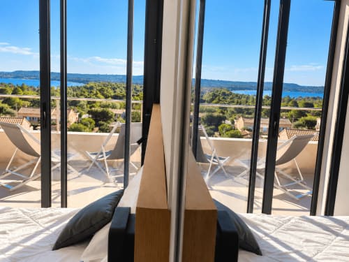 Terrasse luxueuse de Les Villas d'A Storia en Corse avec vue sur mer, transats et paysage méditerranéen