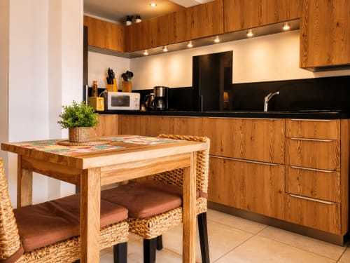 Modern equipped kitchen in Bungalow 2 at Les Balcons D'Oyster Pond, Saint-Martin with wooden cabinetry, black counters and