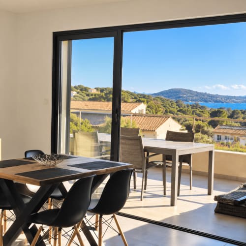 Balcon moderne des Villas d'A Storia avec vue sur mer, espaces repas et paysage côtier corse