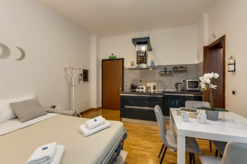 Appartamento Sweet Life al Colosseo a Roma: monolocale moderno con angolo cottura, tavolo da pranzo, letto e vista sulla città