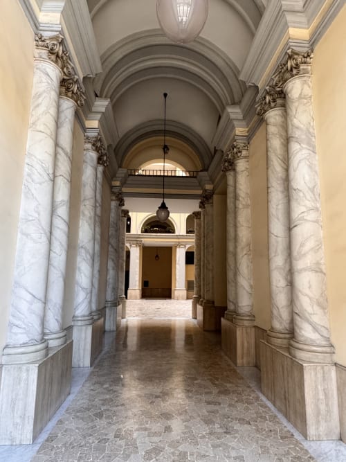 Maestosa hall in marmo con colonne corinzie all'hotel Buonanotte Colosseo di Roma