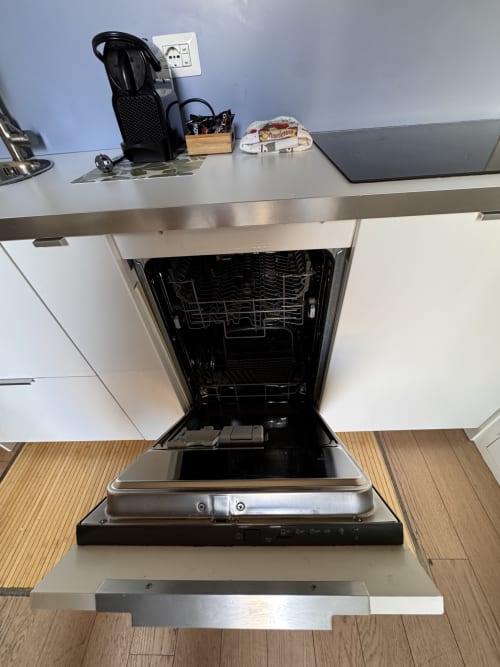 Lavastoviglie aperta nella cucina del B&B Buonanotte Colosseo a Roma, con bancone in acciaio inox e macchina da caffè