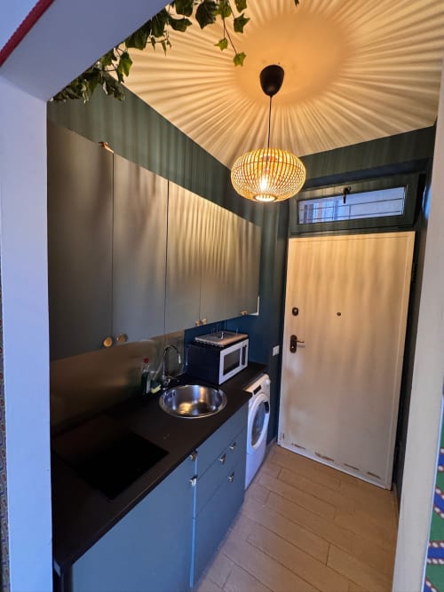 Moderna cucina in Garibaldi Studio Apt presso Buonanotte Colosseo, Roma, con piano nero e lavello in acciaio inox