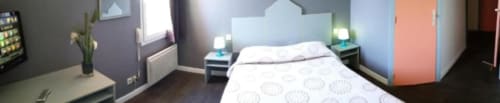 Chambre triple moderne à l'Hôtel Motelia à Moissy-Cramayel avec lit, tables de nuit et décoration contemporaine