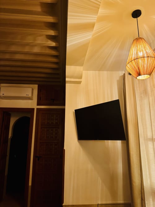 Suite Angelo at Riad Casa Angelo in Marrakech features warm lighting, flat-screen TV, and traditional Moroccan wooden doors