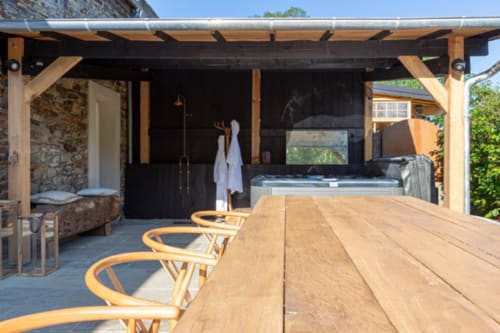 Terrasse pergola moderne avec table et chaises en bois donnant sur spa à Domaine du Tertre Ychot, Dol de Bretagne