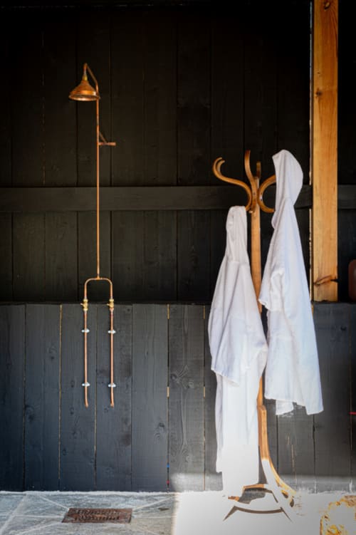 Portmanteau en bois avec serviettes blanches et robinet vintage contre un mur en bois foncé au Domaine du Tertre Ychot, Dol de