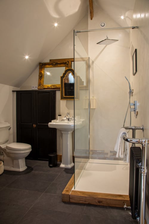 Salle de bains moderne au Domaine du Tertre Ychot avec douche à l'italienne, lavabo sur colonne et miroir orné