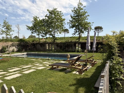 Luxueuse piscine du Domaine du Tertre Ychot à Dol-de-Bretagne avec transats, arbres et terrasse en pierre