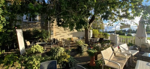 Terrasse ombragée avec transats et vue sur la rivière à la Villa Aliénor B&B aux Andelys