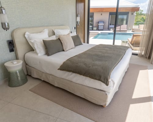 Chambre luxueuse à la Villa Rhéia, Blue Horizon Collection, Guadeloupe, avec vue sur l'océan et piscine accessible par baies vitrées