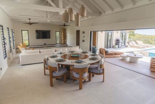 Salle à manger de la Villa Rhéia avec table ronde, salon, terrasse et vue sur la piscine, Collection Blue Horizon