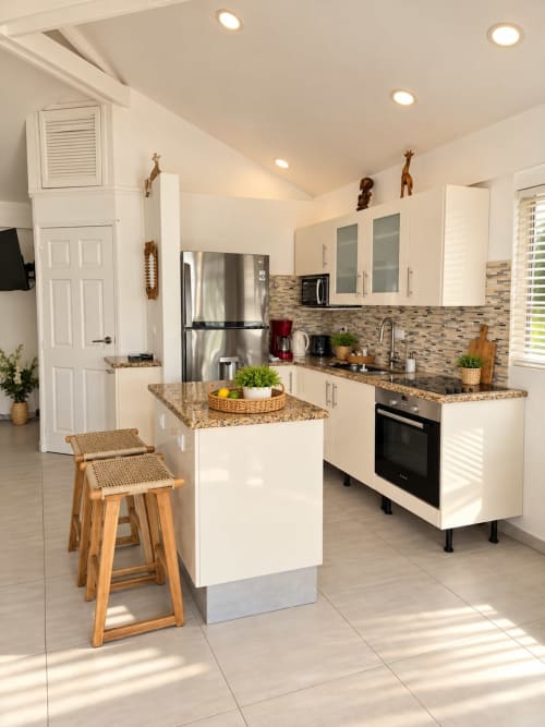 Modern equipped kitchen in Les Balcons D'oyster Pond bungalow, Saint-Martin with white cabinetry, granite counters, stainless