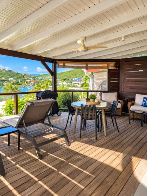 Seaside terrace at Les Balcons D'oyster Pond, Saint-Martin with dining table, lounge chairs, and bay views