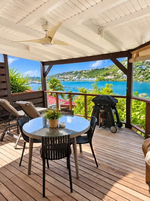 Seaside terrace at Les Balcons D'oyster Pond, Saint-Martin with dining table, lounge chairs, turquoise bay views