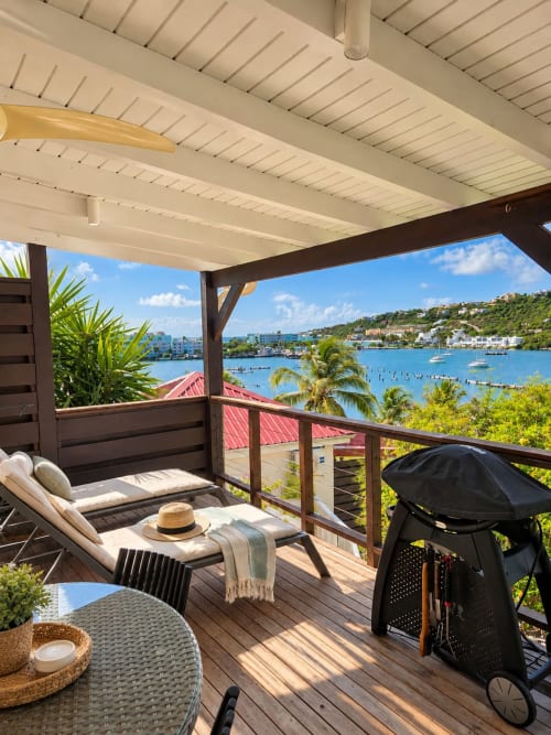 Beachfront bungalow terrace in Saint-Martin with sea view, lounge chairs, and tropical waterfront scenery