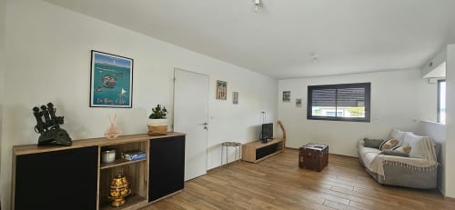 Salon moderne à la Villa Azura, Carcassonne, avec mobilier en bois, sièges confortables, téléviseur écran plat et accès
