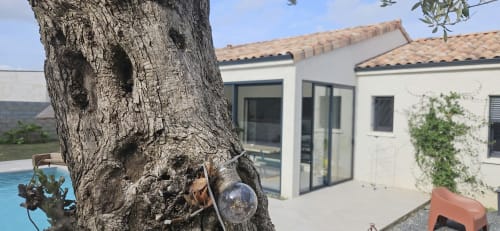 Villa Azura à Carcassonne, maison blanche avec toit en terre cuite, vue sur piscine privée et arbres matures