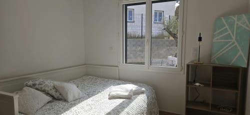 Chambre lumineuse à la Villa Azura, Carcassonne avec lit blanc, mobilier moderne et baies vitrées donnant sur la piscine