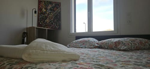 Chambre de Villa Azura à Carcassonne avec literie patterned, coussins et grandes fenêtres donnant sur la piscine