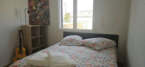 Chambre de la Villa Azura à Mi Casa Es Su Casa, Carcassonne, avec literie fleurie, guitare acoustique et vue sur la piscine