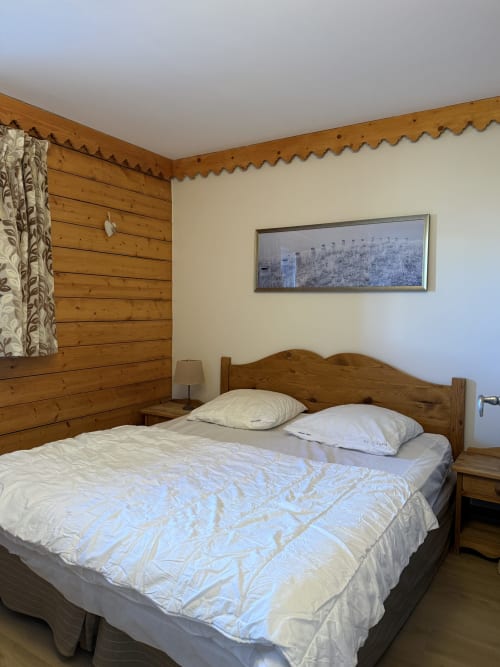 Chambre en bois cosy à La Plagne Ski Confort, Aime 2000, avec lit queen-size, murs en rondins rustiques et décor montagnard