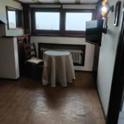 Acogedora habitación doble en Pensión Castio de Santillana del Mar con mesita redonda, TV y vistas a la montaña