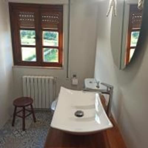 Baño de la Habitación 202 en Pension Castio, Santillana del Mar, con ducha, lavabo, espejo y ventana con vista al jardín