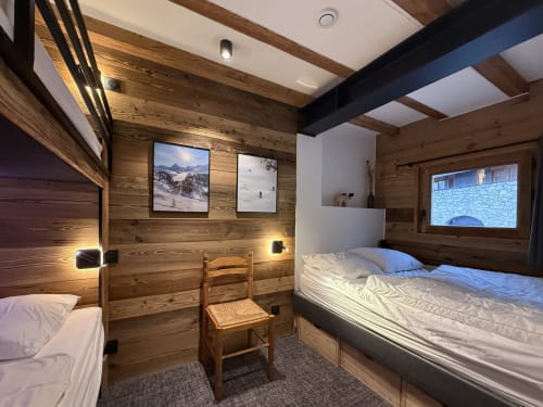 Chambre alpine douillette à La Plagne Ski Confort avec poutres en bois, lits jumeaux, œuvres d'art montagne et équipements modernes