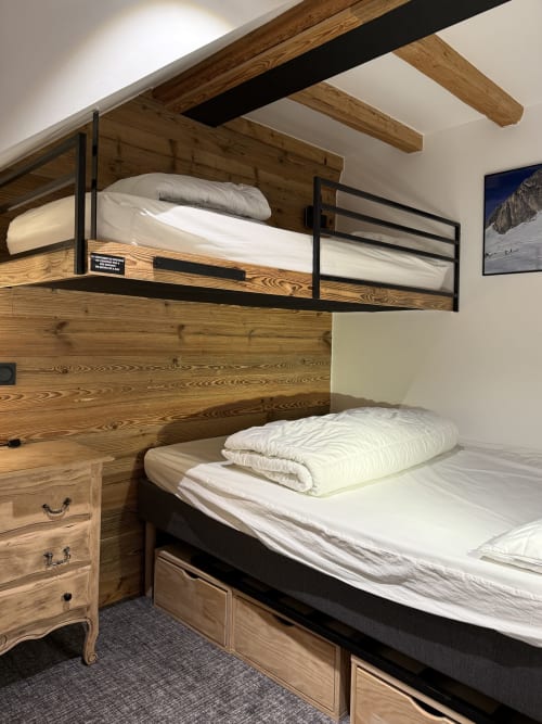 Lits superposés rustiques avec literie blanche dans un appartement de ski à La Plagne, vue montagne et tiroirs de rangement