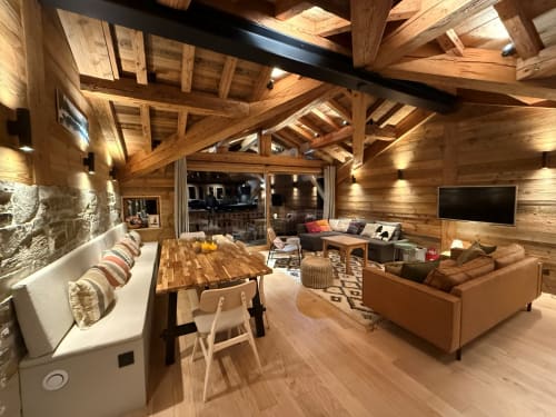 Appartement alpin moderne à La Plagne avec poutres apparentes, table à manger, canapé cuir et vue sur les montagnes