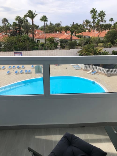 Vista de piscina de Aloe Suite con alberca azul, terrazas y palmeras de Playa del Inglés