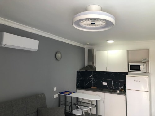 Cocina moderna con backsplash de mármol negro, gabinetes blancos y ventilador de techo en Suite Aloe de Apartamentos Aloe, Playa del