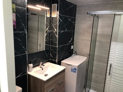 Cuarto de baño moderno en la Suite Aloe de Apartamentos Aloe, Playa del Inglés, con mármol negro, lavamanos, inodoro y