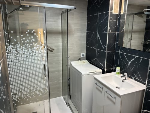 Baño moderno en la Suite ALOE Twin Beds de Apartamentos Aloe, Playa del Inglés con ducha, doble lavamanos y mármol negro