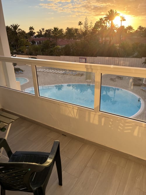 Vista del balcón de la Suite ALOE con vistas a la piscina en Apartamentos Aloe, Playa del Inglés al atardecer