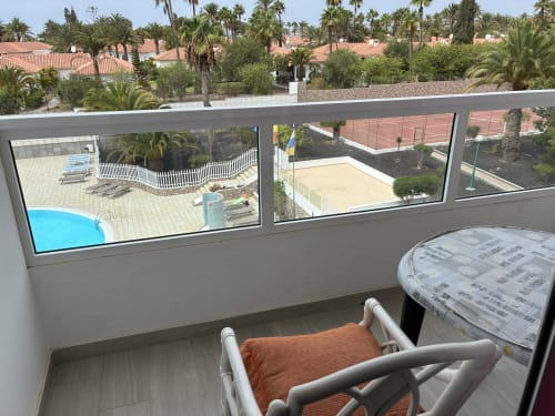 Vista desde el balcón de la Suite Aloe de Apartamentos Aloe con piscina, pistas de tenis y jardines tropicales en Playa del