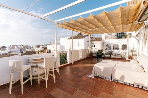 Terraza Deluxe de La Vista Medina con tumbonas, zona de comedor y vistas de Medina Sidonia, España
