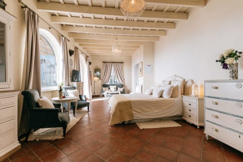 Elegante dormitorio deluxe en La Vista Medina Stays con vigas vistas, pisos de terracota y vistas de la ciudad
