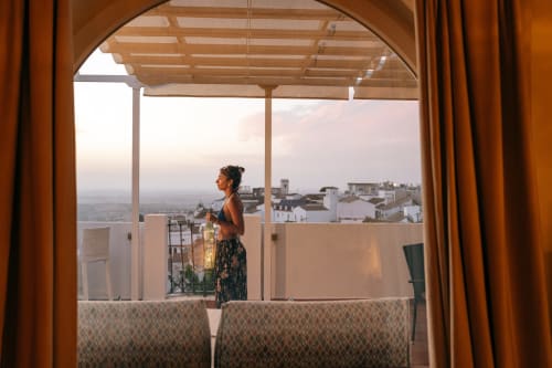 Mujer disfrutando del atardecer desde la terraza con pérgola de La Vista Medina Stays en Medina Sidonia, España