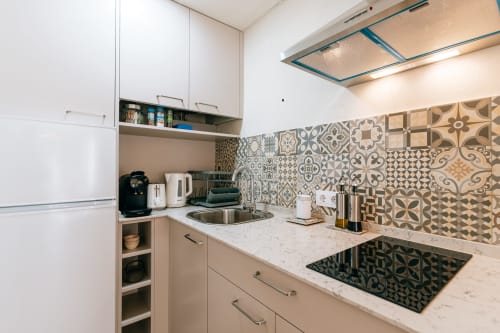 Cocina moderna en estudio La Vista Medina Stays con azulejos decorativos, encimera de mármol y electrodomésticos de acero inoxidable