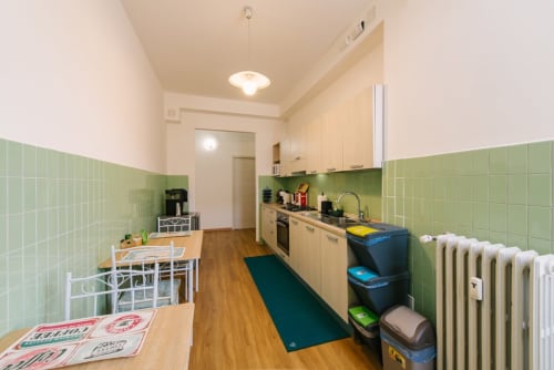 Cucina e zona pranzo spaziosa nell'appartamento di Verona con piastrelle verdi, pavimenti in legno e elettrodomestici moderni