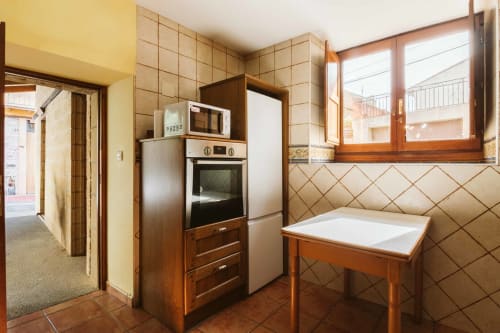 Warm rustic kitchen in La Viña 1 apartment with wooden cabinetry, tiled backsplash, and modern appliances