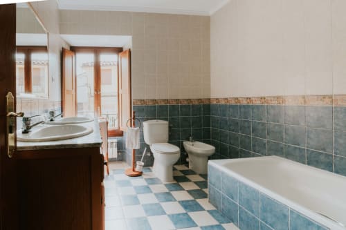 Spacious bathroom in La Viña 1 apartment at Casas Rurales with bathtub, toilet, bidet, dual vanity, and tiled floors