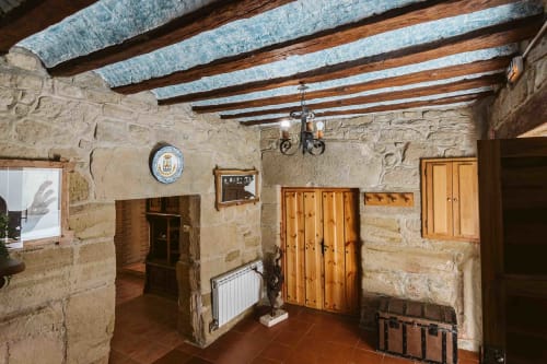 Rustic stone apartment at Casas Rurales La Viña with exposed beams, wooden doors, and traditional Spanish countryside decor